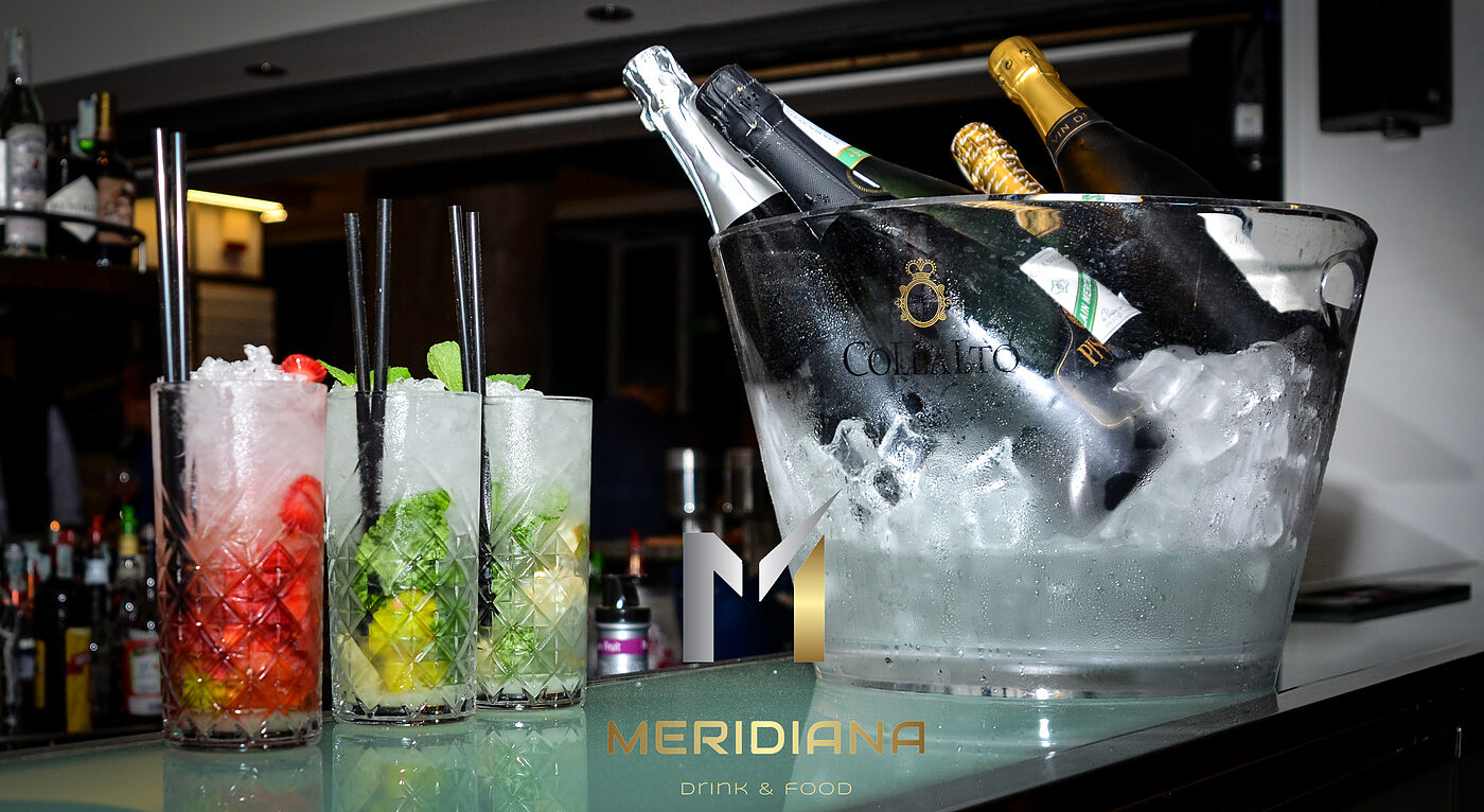 Cocktail e bottiglia di bollicine nel secchiello del ghiaccio