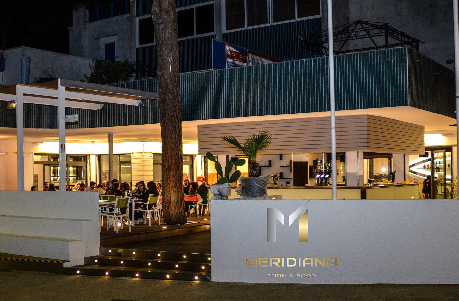 Das Meridiana am Abend, beleuchtete Terrasse unter den Pinien